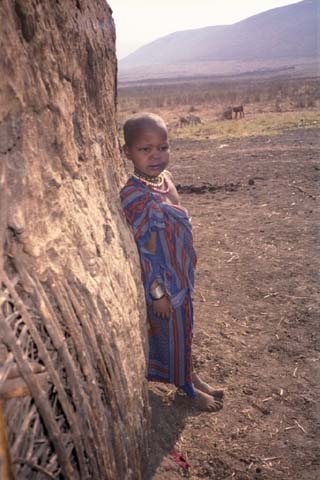 A Masai child looks at us exiting the home